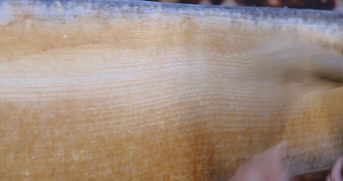 A man using two wooden mallets to beat a wooden semantron. A man using two wooden mallets to beat a wooden semantron