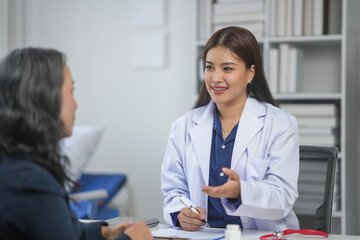 Obraz premium Female doctor having a consultation with a patient, discussing health concerns, in a medical office setting.