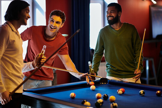 Friends play billiards, laughing and enjoying each others company.