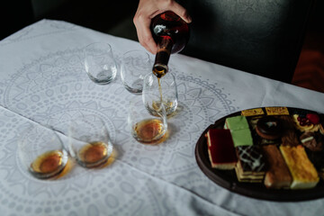 A close-up shot of a drink being poured into a glass, capturing the liquid in motion and highlighting the rich color and texture of the beverage.