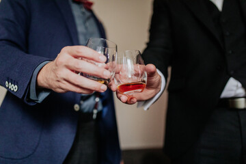 A close-up of hands holding drinks during a celebratory toast