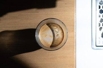 a glass of coffee sits on a table next to a stove.