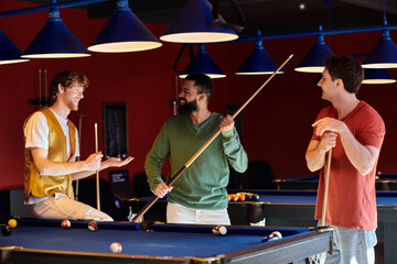 Friends gather around a pool table, laughing and enjoying a casual game of billiards.