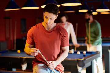 A man concentrates on his shot during a friendly game of billiards.