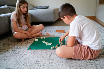 Obraz premium A boy and a girl are playing a game of dominoes