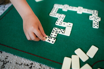 A child is playing with a game of dominoes
