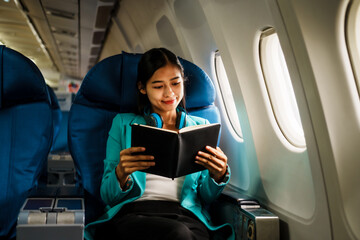 Asian attractive business woman passenger sitting on business class luxury plane while relax while travel concept