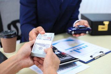 Car insurance documents or rental concept. A car broker helps his customers and explains the...