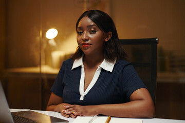 Portrait of Black businesswoman sitting at her office desk