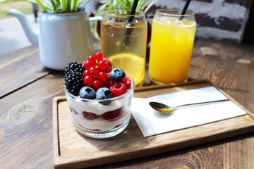 berry desserts and chocolate cake on a wooden table in the interior of the room