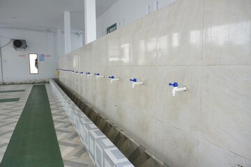 White plastic tap in the mosque ablution area, good for news, articles, posters, advertisements and...