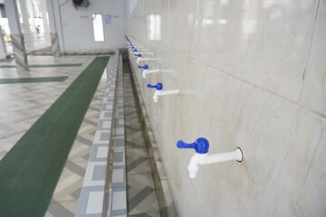 White plastic tap in the mosque ablution area, good for news, articles, posters, advertisements and...