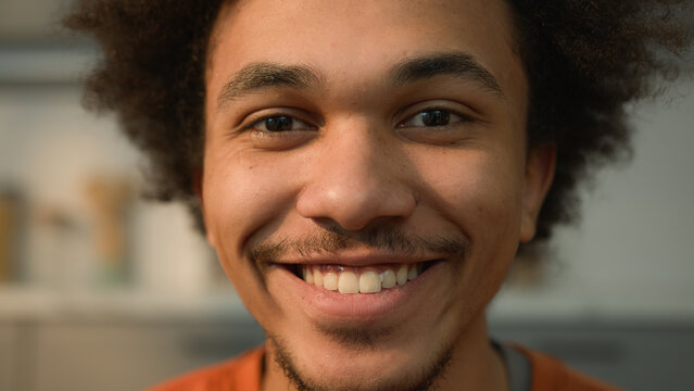 Close up portrait African American ethnic guy male man looking away to side look at camera face healthy happy smiling toothy dental teeth white skincare medicine facial laugh smile fun joy at home