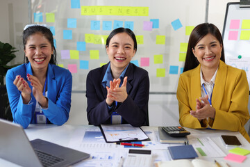 Business meeting, employees are applauding, congratulating and motivation their co-workers. Conference presenting successful business ideas in the office.