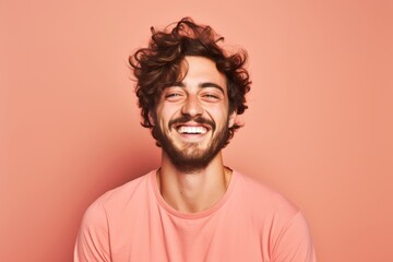 
Portrait photo of a cheerful Caucasian man, 26 years old, winking on a pastel salmon background