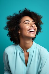 
Portrait photo of a joyful Afro-Caribbean woman, 29 years old, winking on a pastel cyan background