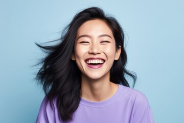 
Portrait photo of a joyful Asian woman, 31 years old, winking on a pastel periwinkle background