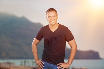 Adult happy man enjoying on top of mountain