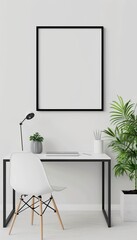 Minimalist home office setup with a black frame on a white wall, a desk, chair, lamp, and greenery for a modern work environment.