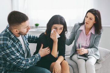 Lady Crying While Husband and Therapist Offer Support During Couples Therapy Session at Modern...