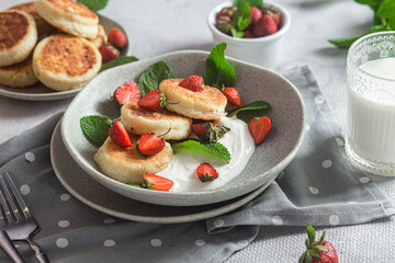Homemade cottage cheese pancakes with sauce and strawberries. syrniki
