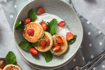 Homemade cottage cheese pancakes with sauce and strawberries. syrniki