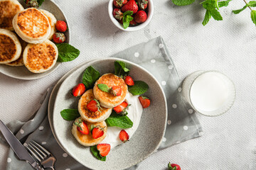 Homemade cottage cheese pancakes with sauce and strawberries. syrniki