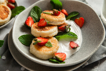 Homemade cottage cheese pancakes with sauce and strawberries. syrniki
