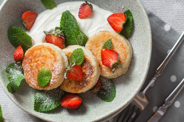Homemade cottage cheese pancakes with sauce and strawberries. syrniki