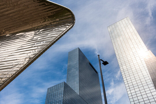This image features a dynamic view of contemporary skyscrapers towering under the blue sky of Rotterdam, Netherlands, showcasing Europe's modern urban landscape