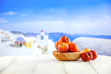Fresh tasty fruits of peaches and white wooden table of empty space for your decoration. Summer landscape and natural sun light. 