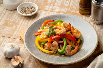 Stir Fried Sweet Peppers with shrimp,Stir fry shrimps and sliced red green and yellow bell pepper with sauce in a plate.healthy food
