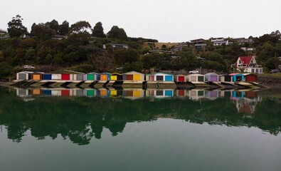 Historic colorful wooden boat sheds on Duvauchelle Bay shore in Akaroa Harbour, Banks Peninsula,...