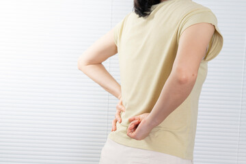 Women with lower back pain, pressing on the waist with their hands