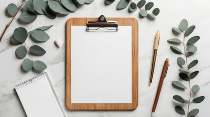 Mockup of wooden clipboard with blank paper on marble table with office supplies and eucalyptus branches. Top view with copy space, flat lay. Flat lay stylised coffee table text space 