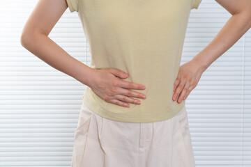 Women with lower back pain, pressing on the waist with their hands
