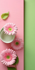 Obraz premium Pink gerber flower and cup of tea on green background.