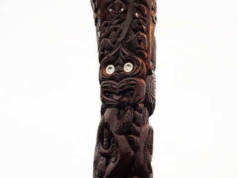 Typical traditional Pou Whenua wooden pole head face Whakairo carving Maori culture at Dawson Falls Taranaki New Zealand