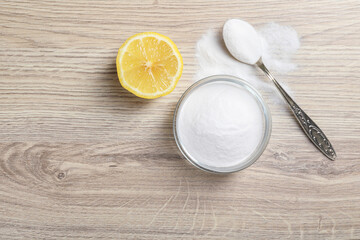 Baking soda and lemon on wooden table, top view. Space for text