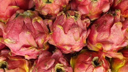 Fototapeta premium Close up pile of tasty fresh dragon fruit sold at the market as a background.
