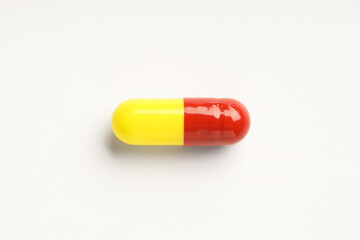 One antibiotic pill on white background, top view