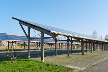 An empty parking lot for cars covered with solar panels. Clean energy transition concept.