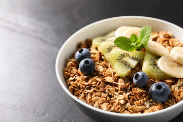 Tasty granola with fresh fruits on grey table, closeup. Space for text
