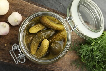 Pickled cucumbers in jar, dill and garlic on grey table, flat lay