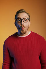 Fototapeta premium Handsome man in stylish attire playfully contorting his face while wearing glasses.