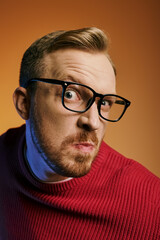 Obraz premium A stylish man in red sweater and eyeglasses striking a pose.