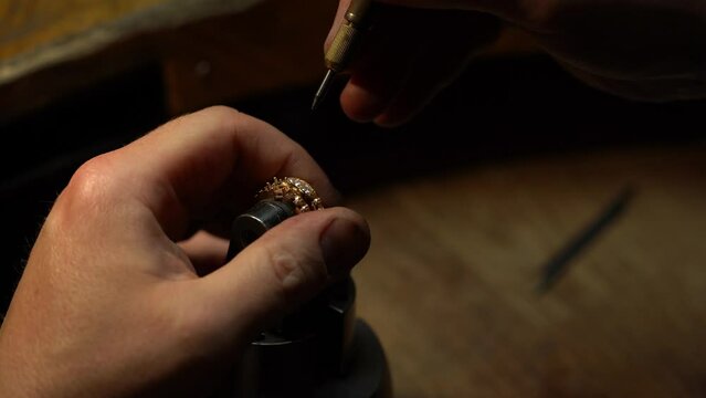 Jeweler puts diamond to golden wedding luxury ring.