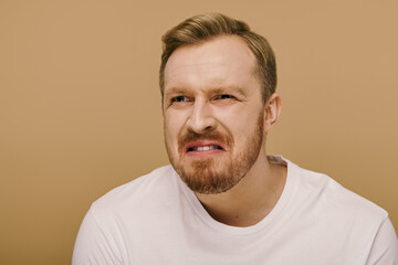 Fototapeta premium A stylish man with a beard in a white shirt striking a pose.