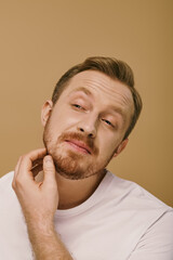 Fototapeta premium Handsome man with beard in white t-shirt striking a fashionable pose.