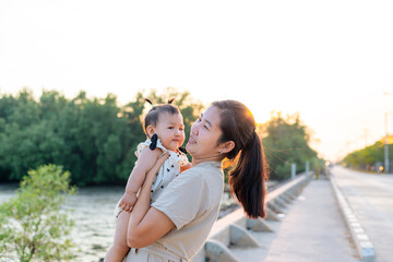 Mother and child,happy harmonious family outdoors. mother throws baby up, laughing and playing in the summer on the nature